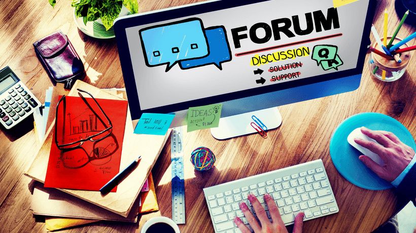 Työpöytä tietokoneen ja toimistotarvikkeiden kanssa. Näytöllä teksti "FORUM".